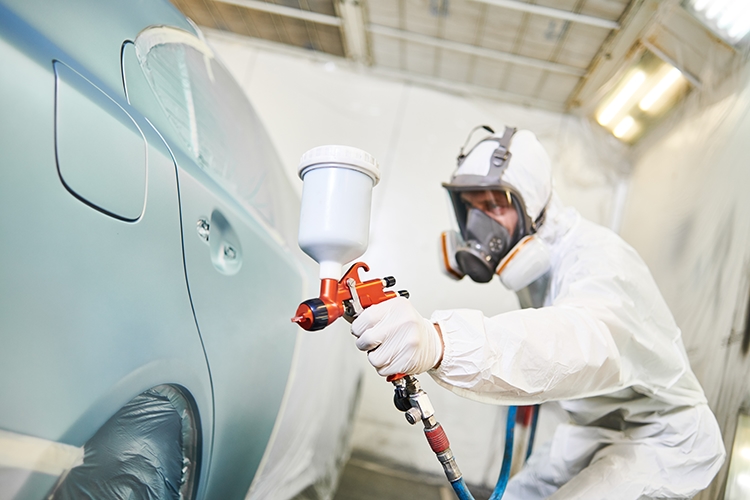 Auto wird mit Lackierpistole lackiert